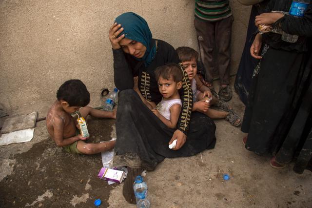An Iraqi woman, who fled the fighting between government forces and Islamic State (IS) group jihadists in the Old City of Mosul, reacts as she sits in the city's western industrial district awaiting to be relocated. (AFP Photo) An Iraqi woman, who fled the fighting between government forces and Islamic State (IS) group jihadists in the Old City of Mosul, reacts as she sits in the city's western industrial district awaiting to be relocated. (AFP Photo)