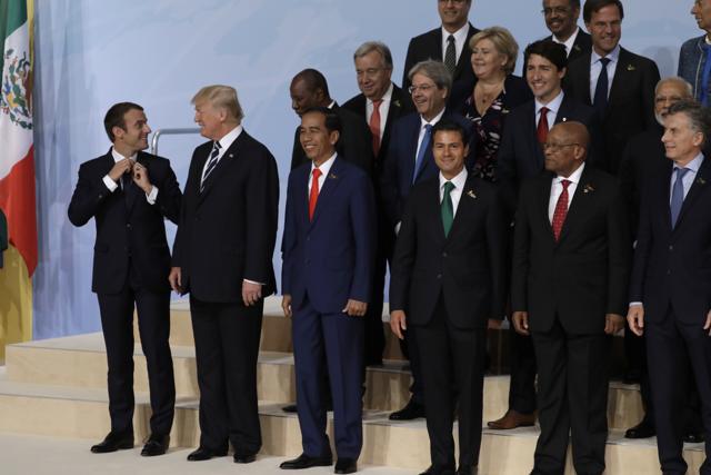 Donald Trump speaks to French President Emmanuel Macron as they participate in the group photo at the G20 Summit on July 7, 2017, in Hamburg. (AP) Donald Trump speaks to French President Emmanuel Macron as they participate in the group photo at the G20 Summit on July 7, 2017, in Hamburg. (AP)