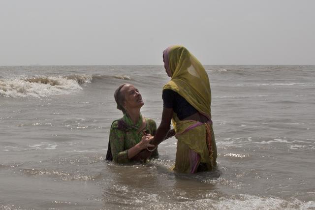 A local woman helps Elizabeth Brenner (L), take a dip in the waters of Gangasagar in West Bengal, India. She believes that part of her son's remains flowed across India through the Ganges river into the Bay of Bengal. (Rishabh R. Jain / AP) A local woman helps Elizabeth Brenner (L), take a dip in the waters of Gangasagar in West Bengal, India. She believes that part of her son's remains flowed across India through the Ganges river into the Bay of Bengal. (Rishabh R. Jain / AP)