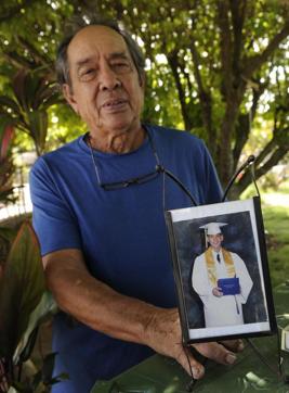 In this Monday, July 10, 2017 photo, Clifford Kang, father of soldier Ikaika E. Kang, poses with photo of his son in Kailua, Hawaii. (AP) In this Monday, July 10, 2017 photo, Clifford Kang, father of soldier Ikaika E. Kang, poses with photo of his son in Kailua, Hawaii. (AP)