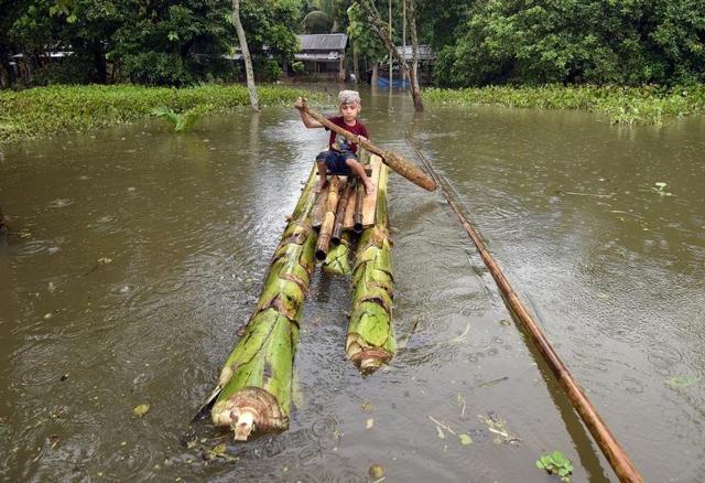 A boy rows a makeshift raft made of banana plants outside his submerged house in the flood-affected Kuthori village near Kaziranga National Park in Nagaon district Assam on July 11. (Reuters) A boy rows a makeshift raft made of banana plants outside his submerged house in the flood-affected Kuthori village near Kaziranga National Park in Nagaon district Assam on July 11. (Reuters)