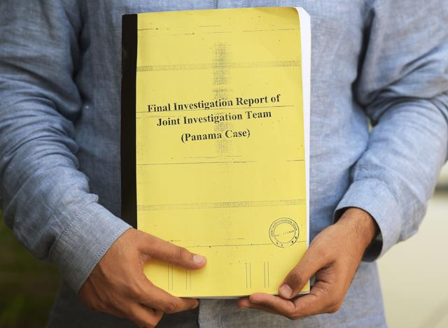 A Pakistani journalist with a copy of the JIT report in Islamabad on July 12, 2017. (AFP) A Pakistani journalist with a copy of the JIT report in Islamabad on July 12, 2017. (AFP)
