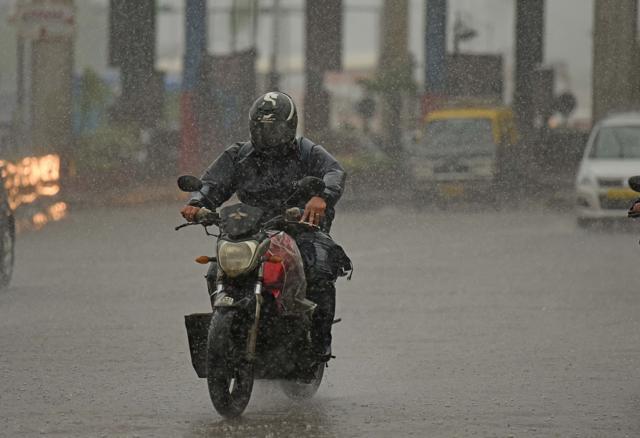 A biker drives through the rain at Dadar in Mumbai. (Satyabrata Tripathy/HT Photo)