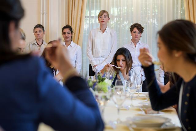 Women sit around an elaborately set table as immaculately starched waiting staff stand at the ready. (AFP) Women sit around an elaborately set table as immaculately starched waiting staff stand at the ready. (AFP)