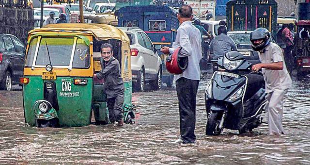 New Delhi: Vehicles make their way through a flooded street after a heavy downpour in New Delhi on Monday. (PTI) New Delhi: Vehicles make their way through a flooded street after a heavy downpour in New Delhi on Monday. (PTI)