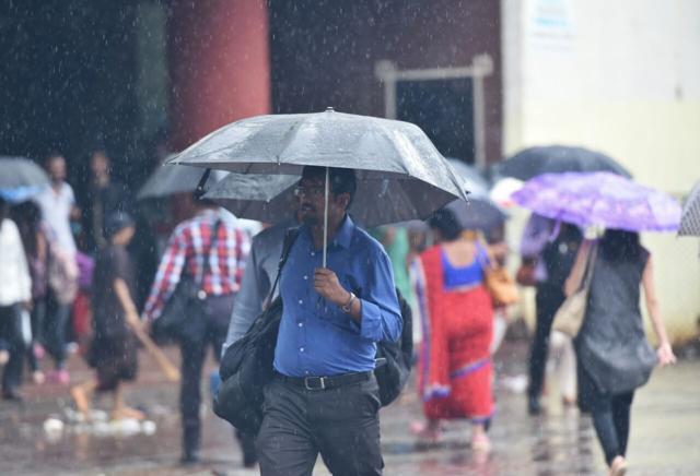 A man balances his umbrella as he heads to work. (Satyabrata Tripathy/HT) A man balances his umbrella as he heads to work. (Satyabrata Tripathy/HT)