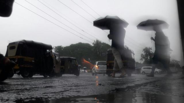 People wade through a waterlogged street in Thane. (Praful Gangurde) People wade through a waterlogged street in Thane. (Praful Gangurde)