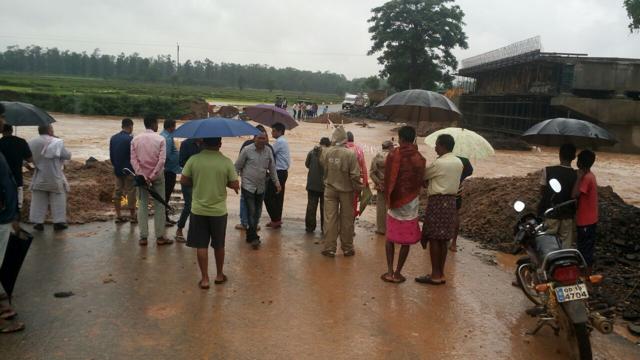 Stranded people look across a flooded road in Malkangiri district (Arabinda Mahapatra / HT Photo) Stranded people look across a flooded road in Malkangiri district (Arabinda Mahapatra / HT Photo)