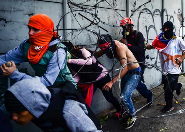 Opposition demonstrators run during clashes with riot police during an anti-government protest in Caracas, on July 20, 2017. (AFP Photo) Opposition demonstrators run during clashes with riot police during an anti-government protest in Caracas, on July 20, 2017. (AFP Photo)