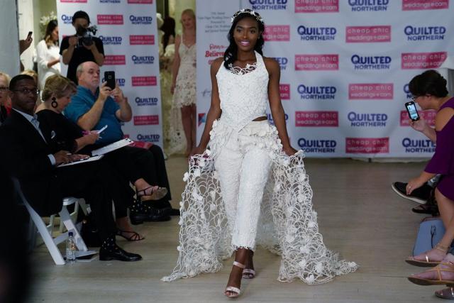 A model presents a wedding dress with an intricately detailed trail resembling lace constructed out of toilet paper. (Carlo Allegri / REUTERS) A model presents a wedding dress with an intricately detailed trail resembling lace constructed out of toilet paper. (Carlo Allegri / REUTERS)