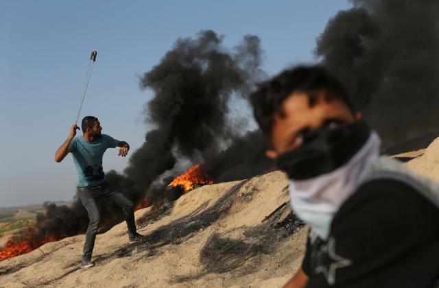 A Palestinian protester uses a sling to hurl stones towards Israeli troops during clashes near the border between Israel and central Gaza Strip July 21. (Reuters Photo) A Palestinian protester uses a sling to hurl stones towards Israeli troops during clashes near the border between Israel and central Gaza Strip July 21. (Reuters Photo)