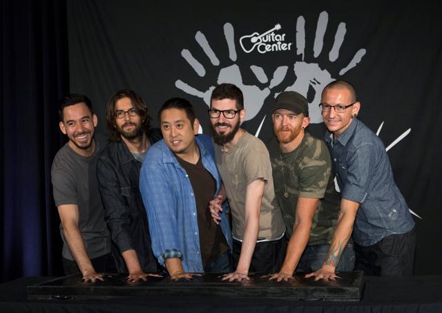 Members of rock band Linkin Park (L-R) Mike Shinoda, Rob Bourdon, Joe Hahn, Brad Delson, Dave Farrell and Chester Bennington put their handprints in cement as they are inducted into Guitar Center's RockWalk in Los Angeles, California June 18, 2014. (REUTERS)