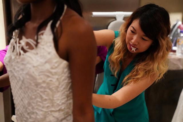 A designer is pictured backstage fixing a wedding dress made out of toilet paper before the model heads out on to the ramp. (Carlo Allegri / REUTERS) A designer is pictured backstage fixing a wedding dress made out of toilet paper before the model heads out on to the ramp. (Carlo Allegri / REUTERS)