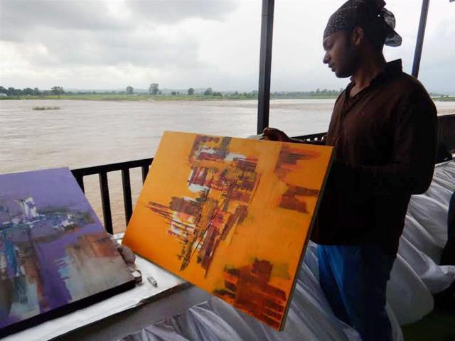 Artist Arihant Jain, pictured here with his abstract portrait of a cityscape, is among the artists who are taking part in the workshop held to pay tribute to the legendary painter S H Raza in Mandla. (PTI) Artist Arihant Jain, pictured here with his abstract portrait of a cityscape, is among the artists who are taking part in the workshop held to pay tribute to the legendary painter S H Raza in Mandla. (PTI)