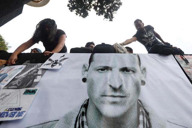 Fans stick posters as they gather at Revolucion monument to pay tribute to Chester Bennington, Linkin Park frontman, following the singer's death by suicide, in Mexico City on July 23. (REUTERS)