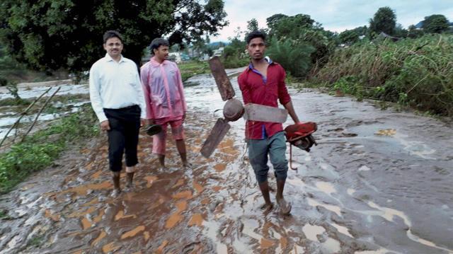 A man holding fan comes out of a flood hit village of Kalyansingpur in Rayagada district, Odisha on July 17, 2017. (PTI)