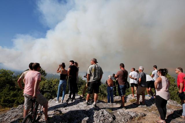 People look at smoke from a wildfire that rises from trees in woods near Seillons, in the Var department, France, July 25. (Reuters Photo) People look at smoke from a wildfire that rises from trees in woods near Seillons, in the Var department, France, July 25. (Reuters Photo)