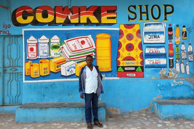 Muawiye Hussein Sidow, also known as Shik Shik, stands in front of a mural he painted on a shop wall in Mogadishu. (Feisal Omar / REUTERS) Muawiye Hussein Sidow, also known as Shik Shik, stands in front of a mural he painted on a shop wall in Mogadishu. (Feisal Omar / REUTERS)