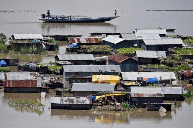 Villagers use a boat as they row past partially submerged houses at a flood-affected village in Morigaon district in Assam. (Reuters Photo) Villagers use a boat as they row past partially submerged houses at a flood-affected village in Morigaon district in Assam. (Reuters Photo)