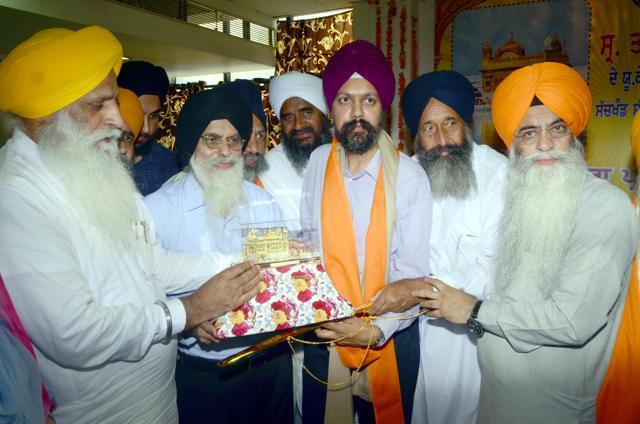 SGPC members honouring Tanmanjeet Singh Dhesi (centre) and his father at Golden Temple, Amritsar, on Wednesday, July 25. (Sameer Sehgal/HT)
