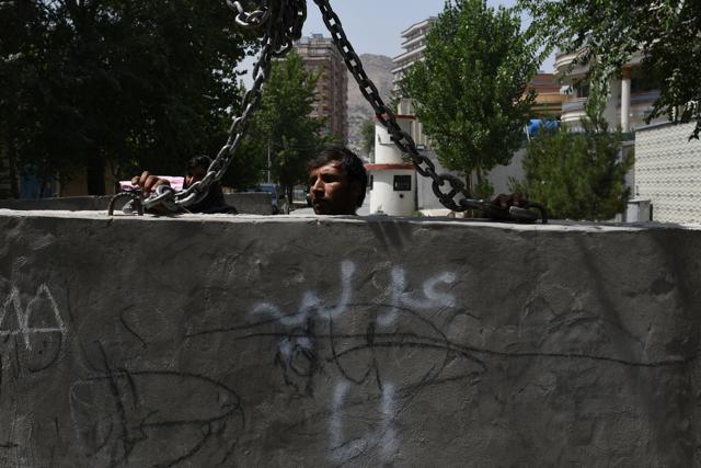 An Afghan government worker removes blast walls in Kabul. (AFP Photo) An Afghan government worker removes blast walls in Kabul. (AFP Photo)