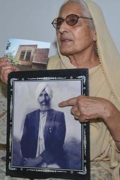 Sushwant Kaur, 78, showing a photograph of her late father Sulkhan Singh in Amritsar. (AFP Photo)