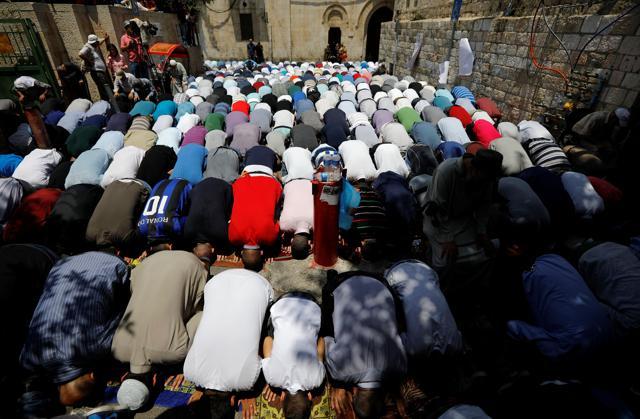 Palestinian men pray outside the compound known to Muslims as Noble Sanctuary and to Jews as Temple Mount, just outside Jerusalem's Old City, on July 27, 2017.  (Reuters)