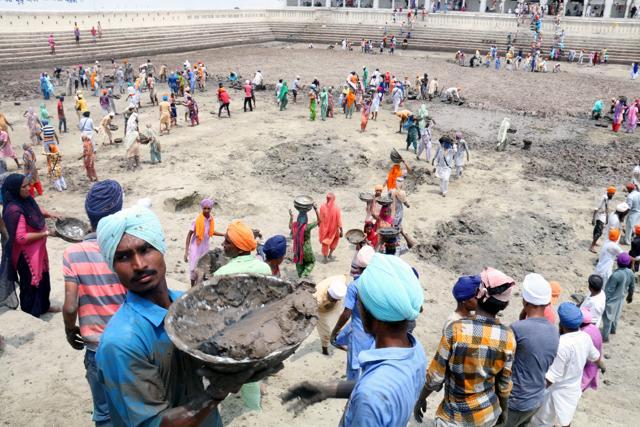 Devotees from villages were seen taking away the silt extracted from the pond to their homes as they consider it sacred. (Sanjeev Kumar/HT Photo) Devotees from villages were seen taking away the silt extracted from the pond to their homes as they consider it sacred. (Sanjeev Kumar/HT Photo)