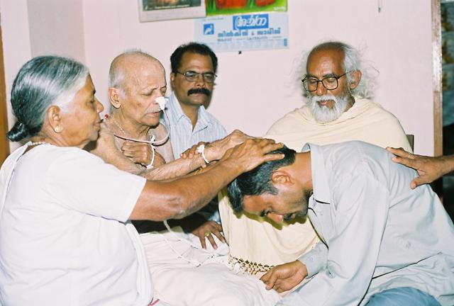Samandar Singh bends to recieve forgiveness from Sister Rani Maria’s mother and father at the latter’s home in Pulluvazhy, Kerala, in 2007. Also in the picture, Father Sadanand (with white beard) who helped the reconciliation to take place. (Photo courtesy/Sister Selmy Paul)