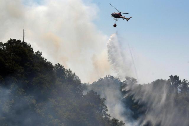 A helicopter drops water as firefighters work to extinguish a wild fire in Mount Dajti, east of capital Tirana, in Albania on Friday. (AFP) A helicopter drops water as firefighters work to extinguish a wild fire in Mount Dajti, east of capital Tirana, in Albania on Friday. (AFP)