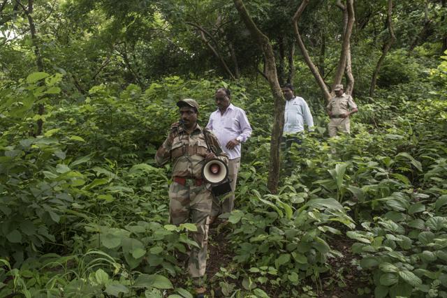Forest department officials using a megaphone to warn people about the impending danger on Thursday. (Satish Bate/HT) Forest department officials using a megaphone to warn people about the impending danger on Thursday. (Satish Bate/HT)