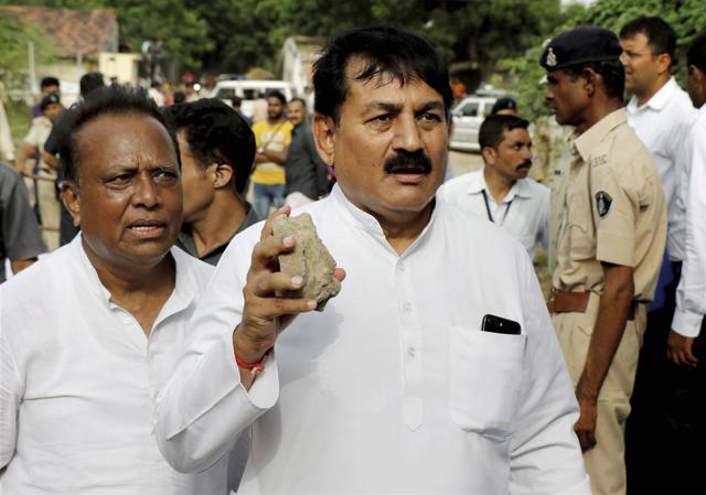 Congress leader Bharatsinh Solanki shows the stone pelted at party vice president Rahul Gandhi's car during his visit to the flood-affected Dhanera village of Gujarat’s Banaskantha district on Friday. (PTI) Congress leader Bharatsinh Solanki shows the stone pelted at party vice president Rahul Gandhi's car during his visit to the flood-affected Dhanera village of Gujarat’s Banaskantha district on Friday. (PTI)