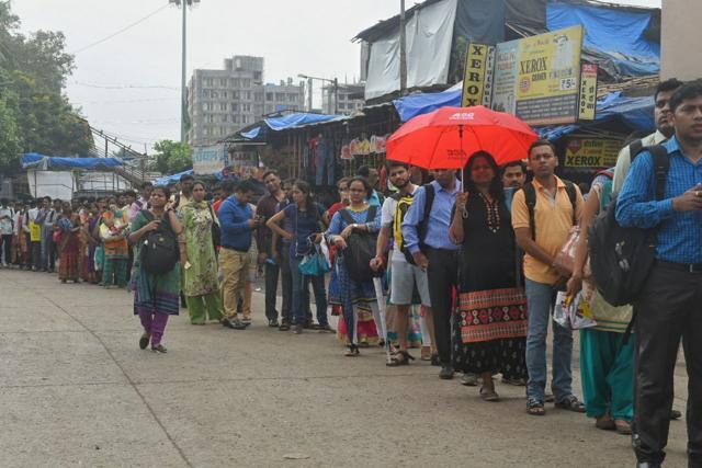 Exhausted commuters stand in queue outside Kurla railway station. (Pratik Chorge/HT)