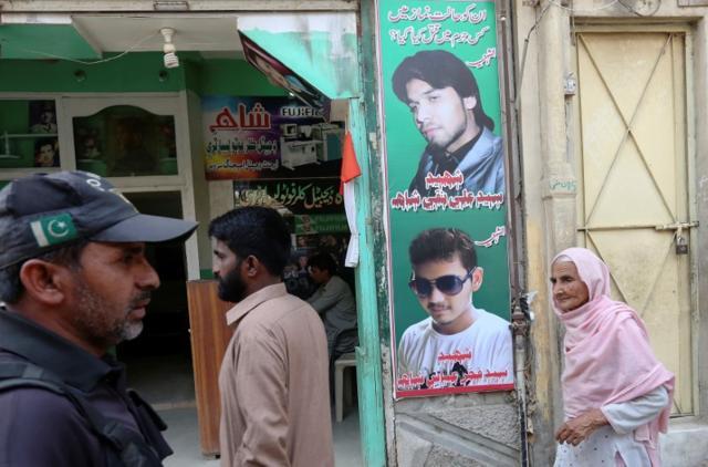 A policeman (L) and residents walk past a shop displaying the pictures of men, who were killed in a suicide blast on January 2015, in a Shi'ite mosque in Shikarpur. (Reuters) A policeman (L) and residents walk past a shop displaying the pictures of men, who were killed in a suicide blast on January 2015, in a Shi'ite mosque in Shikarpur. (Reuters)