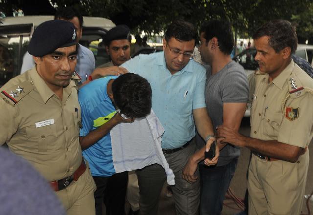 Vikas Baralaâ (hiding his face) being taken for medical examination after arrest. (Karun Sharma/HT)