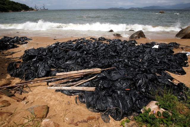 Garbage bags containing collected crystallised palm oil are seen on a beach at Lamma Island in Hong Kong. (Reuters Photo) Garbage bags containing collected crystallised palm oil are seen on a beach at Lamma Island in Hong Kong. (Reuters Photo)