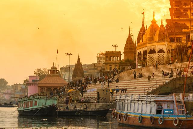 Scenic view from the river on Ghat with crowd. Sunset colours the temples. (Getty Images)