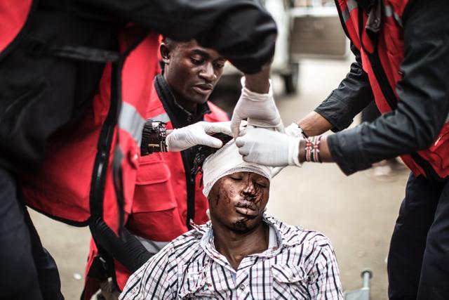 Emergency workers take care of a wounded man after about 15 people were allegedly beaten during a police raid, following overnight protests against the election results. (AFP Photo)