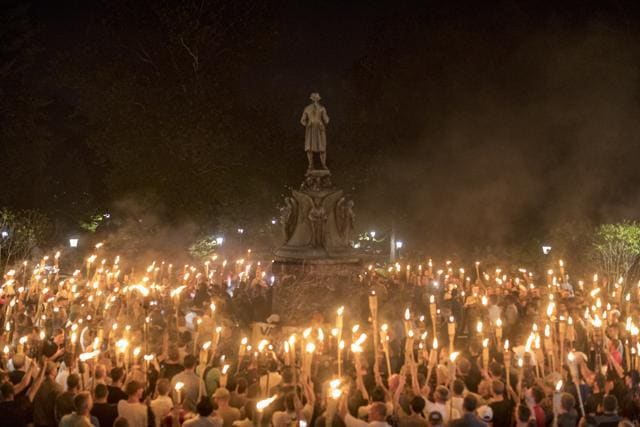 Torch-bearing white nationalists rally around a statue of Robert E Lee, the Confederate general, near the University of Virginia campus in Charlottesville on Friday night. (NYT) Torch-bearing white nationalists rally around a statue of Robert E Lee, the Confederate general, near the University of Virginia campus in Charlottesville on Friday night. (NYT)