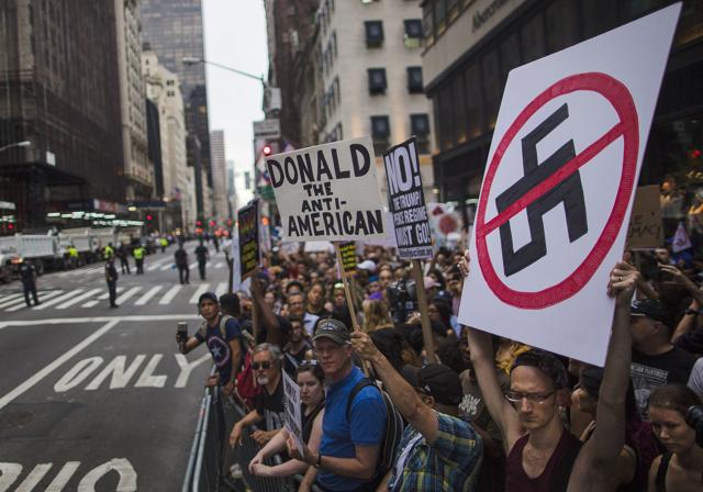 Protesters shout slogans and hold signs against President Donald Trump in front of Trump Tower ahead his first visit to the building since taking office. (AP) Protesters shout slogans and hold signs against President Donald Trump in front of Trump Tower ahead his first visit to the building since taking office. (AP)