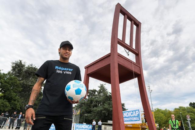 Brazilian superstar and world's most expensive footballer Neymar poses next to the monumental wood sculpture "Broken Chair" during an event organized by NGO Handicap International on August 15, 2017 at the Place des Nations in Geneva. Neymar has been appointed as new goodwill ambassador for Handicap International an NGO aiming to help disabled and vulnerable people in situations of poverty and exclusion, conflict and disaster. (AFP) Brazilian superstar and world's most expensive footballer Neymar poses next to the monumental wood sculpture "Broken Chair" during an event organized by NGO Handicap International on August 15, 2017 at the Place des Nations in Geneva. Neymar has been appointed as new goodwill ambassador for Handicap International an NGO aiming to help disabled and vulnerable people in situations of poverty and exclusion, conflict and disaster. (AFP)
