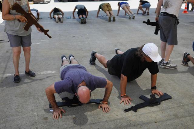 Foreign tourists train with a wooden gun as they participate in a two hour anti-terror course at the Caliber 3 shooting range. (AFP Photo) Foreign tourists train with a wooden gun as they participate in a two hour anti-terror course at the Caliber 3 shooting range. (AFP Photo)
