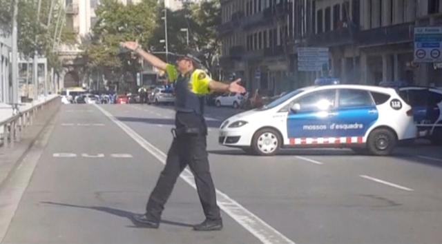 A still image from video shows a police officer gesturing while walking across a road, after a van crashed into people in the centre of Barcelona, Spain, August 17, 2017. (REUTERS) A still image from video shows a police officer gesturing while walking across a road, after a van crashed into people in the centre of Barcelona, Spain, August 17, 2017. (REUTERS)