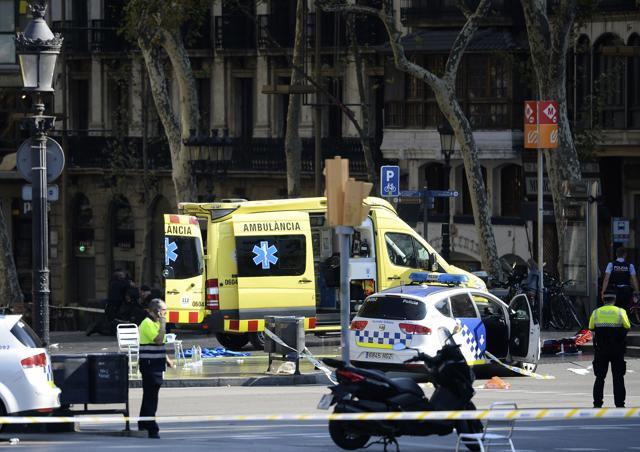 A policemen and a medical staff member stand past police cars and an ambulance in a cordoned off area after a van ploughed into the crowd, injuring several persons on the Rambla in Barcelona. (AFP Photo) A policemen and a medical staff member stand past police cars and an ambulance in a cordoned off area after a van ploughed into the crowd, injuring several persons on the Rambla in Barcelona. (AFP Photo)