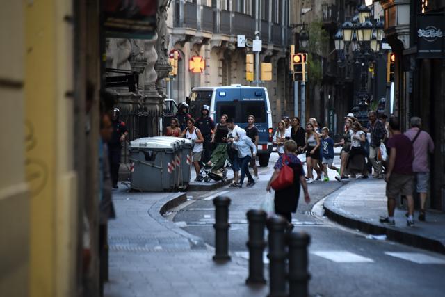 People flee the scene in Barcelona, Spain, Thursday, Aug. 17, 2017, as police officers patrols after a white van jumped the sidewalk in the historic Las Ramblas district, crashing into a summer crowd of residents and tourists and injuring several people, police said. (AP) People flee the scene in Barcelona, Spain, Thursday, Aug. 17, 2017, as police officers patrols after a white van jumped the sidewalk in the historic Las Ramblas district, crashing into a summer crowd of residents and tourists and injuring several people, police said. (AP)