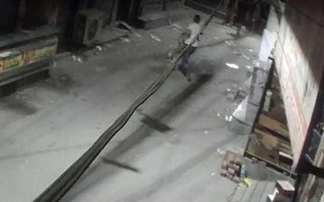Grab from CCTV footage shows man waking away with the dead dog. Grab from CCTV footage shows man waking away with the dead dog.