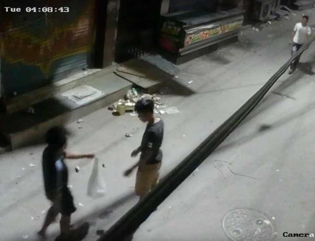 CCTV grab shows one of the youths getting a bag to take away the dog. CCTV grab shows one of the youths getting a bag to take away the dog.