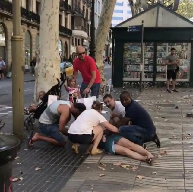 People help an injured woman lying on the ground after a van crashed into pedestrians near the Las Ramblas avenue in central Barcelona, Spain August 17, 2017. (REUTERS) People help an injured woman lying on the ground after a van crashed into pedestrians near the Las Ramblas avenue in central Barcelona, Spain August 17, 2017. (REUTERS)