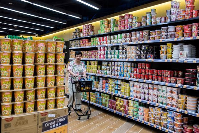 A customer walks past different brands of instant noodles for sale at a supermarket in Hong Kong. (AFP)