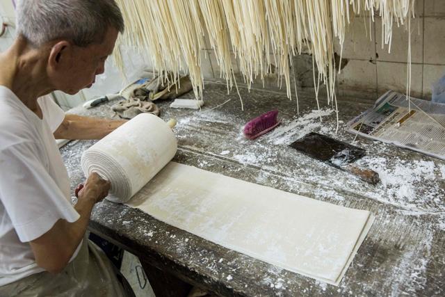 Ho Shun-kan, owner of Kan Kee Noodles, portioning out dough, that will then be used to make different types of noodles that he sells direct to customers and surrounding restaurants, in his shop in the Central district of Hong Kong. (AFP)